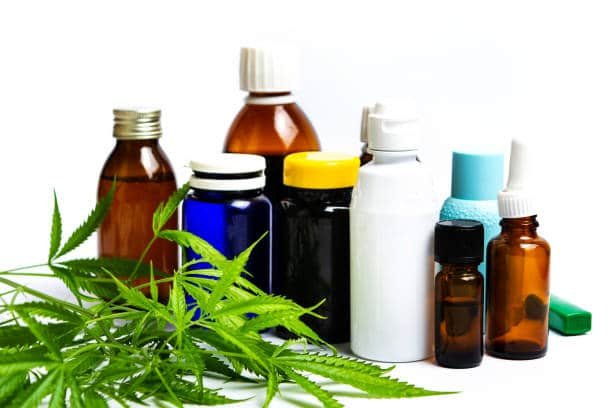 Plante de marijuana et bouteilles d'huile médicale de cannabis sur fond blanc isolé